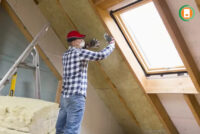 Certified installer laying premium insulation material between roof joists during an ECO4 grant-funded home upgrade